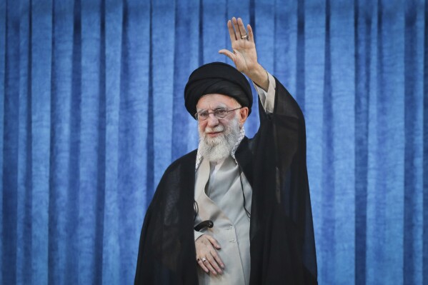 In this photo released by the official website of the office of the Iranian supreme leader, Supreme Leader Ayatollah Ali Khamenei waves to the crowd as he arrives for a ceremony marking the anniversary of the 1989 death of the late revolutionary founder Ayatollah Khomeini at his shrine just outside Tehran, Iran, Wednesday, June 4, 2025. (Office of the Iranian Supreme Leader via AP)