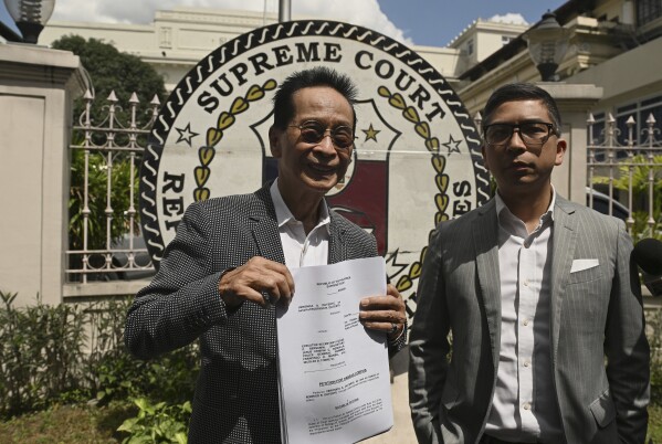 Salvador Panelo, former presidential spokesman and chief presidential legal counsel of Philippine former President Rodrigo Duterte, shows a copy of the Habeas Corpus petition before filing it at the Supreme Court on Wednesday, March 11, 2025 in Manila, Philippines (AP Photo/Noel Celis)