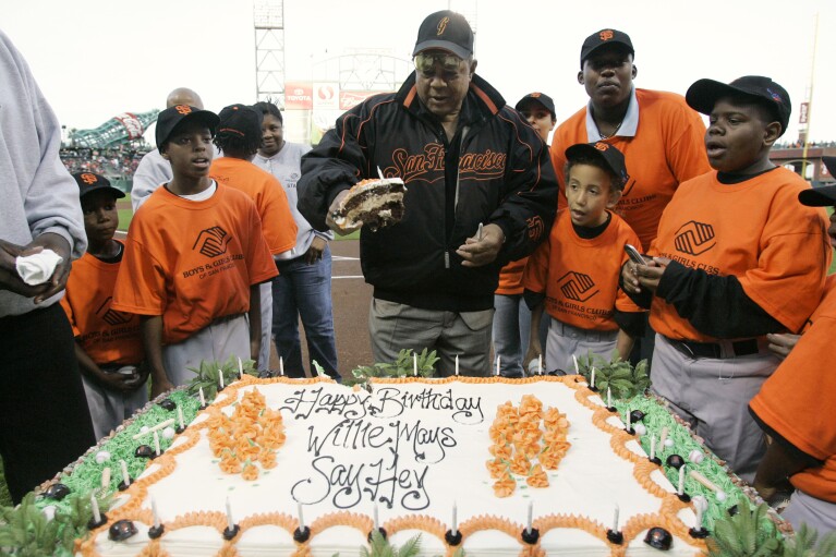 FILE - Willie Mays is surrounded by children from the Boys and Girls Club of San Francisco as he celebrates his birthday, before a baseball game between the San Francisco Giants and the Philadelphia Phillies in San Francisco, May 4, 2007. Mays, the electrifying “Say Hey Kid” whose singular combination of talent, drive and exuberance made him one of baseball’s greatest and most beloved players, has died. He was 93. Mays' family and the San Francisco Giants jointly announced Tuesday night, June 18, 2024, he had “passed away peacefully” Tuesday afternoon surrounded by loved ones. (AP Photo/Marcio Jose Sanchez. File)