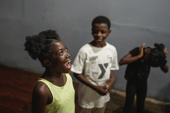 Juliana St. Vil, 12, who now lives in a shelter after fleeing gang violence in her neighborhood, rehearses her role in a skit for an acting workshop called “Theater Curbs Violence” in Port-au-Prince, Haiti, on Wednesday, May 15, 2024. The skit, which depicts life in a shelter in Haiti, will be performed for the public at the end of the two-week workshop. (AP Photo/Ramon Espinosa)