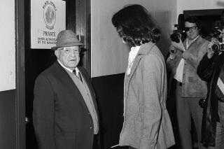 FILE - Robin Herman, sports writer for the New York Times, is confronted by Chicago Black Hawks doorman Gordon Robertson outside the Black Hawks dressing room in Chicago, on Jan. 24, 1975. Herman, a gender barrier breaking reporter who was the first female sports journalist to interview players in the locker room after an NHL game, died Tuesday, Feb. 2, 2022, of ovarian cancer at her Waltham, Mass., home. She was 70.  (AP Photo/File)