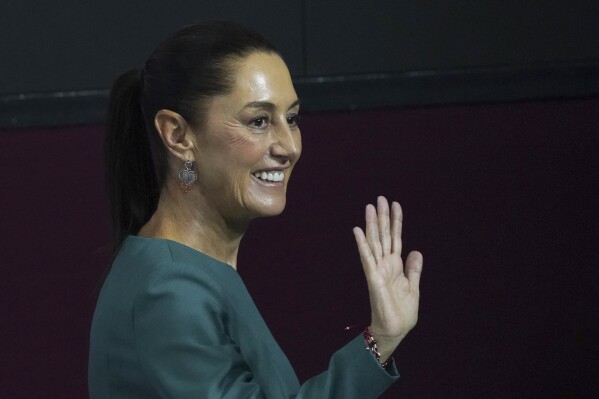 FILE - Incoming President Claudia Sheinbaum waves at the end of a press conference where she presented four more members of her Cabinet, in Mexico City, July 4, 2024. Outgoing President Andrés Manuel López Obrador said Wednesday, July 10, 2024, his successor is planning to build three passenger train lines running from the capital to some cities on the U.S. border. (AP Photo/Marco Ugarte, File)