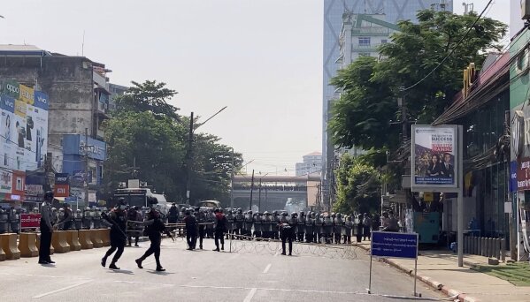 In this image made from video, a row of riot police blocks the road to prevent protesters from marching forward Saturday, Feb. 6, 2021 in Yangon, Myanmar.  Myanmar’s new military authorities appeared to have cut most access to the Internet on Saturday as they faced a rising tide of protest over their coup that toppled Aung San Suu Kyi's elected civilian government.(AP Photo)