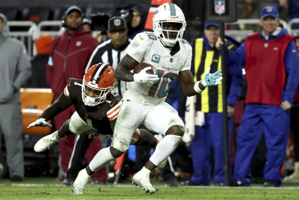 Miami Dolphins wide receiver Tyreek Hill (10) runs past Cleveland Browns safety Juan Thornhill (1) during an NFL football game, Sunday, Dec. 29, 2024, in Cleveland. (AP Photo/Kirk Irwin)