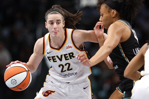 Indiana Fever guard Caitlin Clark (22) drives to the basket against New York Liberty forward Betnijah Laney-Hamilton (44) during the first half of a WNBA basketball game, Saturday, May 18, 2024, in New York. (AP Photo/Noah K. Murray)