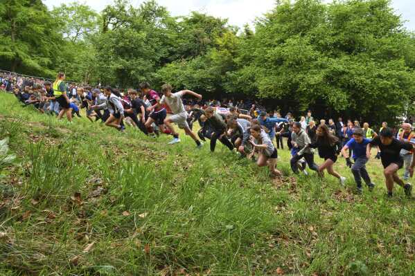 Children under 11 start for the uphill competition during the traditional annual Cheese Rolling contest at Cooper's Hill in Brockworth, Gloucestershire, England, Monday, May 26, 2025.(AP Photo/Anthony Upton)