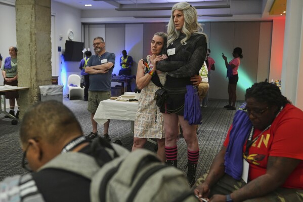 Marion F., left, and her partner Jessie G., embrace as they listen to speakers during a pre-rally with the National Trans Visibility March, held at the Human Rights Campaign, before marching to join the World Pride Rally on the National Mall, Sunday, June 8, 2025, in Washington. (AP Photo/Jacquelyn Martin)
