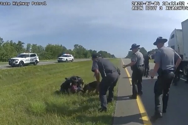 This image taken from police body cam video shows a police dog attacking Jadarrius Rose, 23, of Memphis, Tennessee on Tuesday, July 4, 2023, in Circleville, Ohio. An investigation has been launched into why an Ohio officer allowed his police dog to attack a truck driver who was surrendering with his hands raised, despite State Highway Patrol troopers urging the officer to hold the dog back. (Ohio State Highway Patrol via AP)