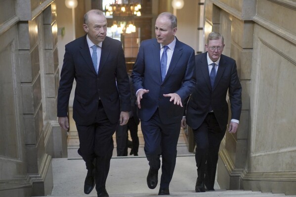 From left, Northern Ireland Secretary Chris Heaton-Harris, Tanaiste Micheal Martin, and Parliamentary Under-Secretary of State for Northern Ireland Lord Caine arrive for the British-Irish intergovernmental Conference presser, at 100 Parliament Street, in London, Monday April 29, 2024. (Yui Mok/Pool via AP)