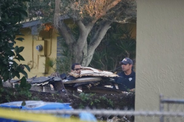 First responders work the scene of house explosion early Tuesday, Dec. 19, 2023 in West Park, Fla. Investigators were trying to determine the cause that injured four people in the suburb of the Fort Lauderdale-Hollywood area. (Joe Cavaretta /South Florida Sun-Sentinel via AP)