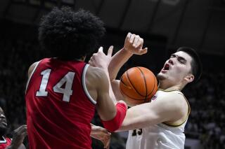Purdue center Zach Edey (15) is fouled day Ohio State forward Justice Sueing (14) in the second half of an NCAA college basketball game in West Lafayette, Ind., Sunday, Feb. 19, 2023. Purdue defeated Ohio State 82-55. (AP Photo/Michael Conroy)