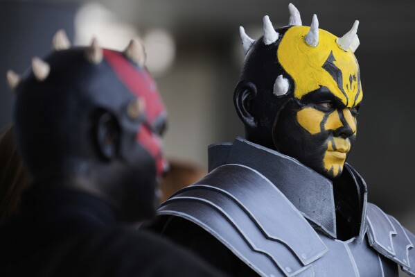 Star Wars fans wearing costumes of Darth Maul, left, and his brother Savage Opress pose for a photo outside the venue during a fan convention called the Star Wars Celebration in Chiba, near Tokyo, Friday, April 18, 2025. (AP Photo/Hiro Komae)