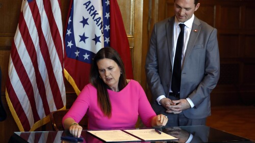 FILE - Arkansas Gov. Sarah Huckabee Sanders signs a bill requiring age verification before creating a new social media account as Sen. Tyler Dees, R-Siloam Springs, looks on during a signing ceremony, Wednesday, April 12, 2023, at the state Capitol in Little Rock, Ark. , NetChoice, a tech industry trade group, is suing Arkansas over its law requiring parental permission for minors to create new social media accounts. (Thomas Metthe/Arkansas Democrat-Gazette via AP)