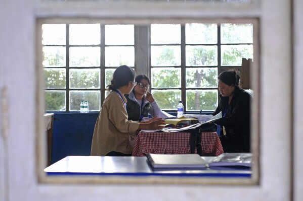 Polling officers, left to right, Neke W Konyak, 29, Neichutuonuo Yhome, 27, and Nukutholu Nienu, 44, prepare election related paperwork on the eve of polling in Chedema village, in the northeastern Indian state of Nagaland, Thursday, April 18, 2024. (AP Photo/Yirmiyan Arthur)