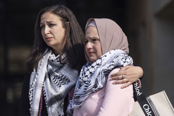 Shaimaa Zayan, left, holds Odi Doar, the mother of stabbing victim Zacharia Doar, as they stand near the podium during a press conference outside City Hall, Tuesday, Feb. 6, 2024, in Austin, Texas. The stabbing of Zacharia Doar, a Palestinian-American, who advocates say was attacked near the University of Texas campus while riding in a car displaying support for Palestine merits the label of a hate crime, police announced Wednesday. (Mikala Compton /Austin American-Statesman via AP)