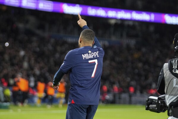 PSG's Kylian Mbappe celebrates after scoring his side's third goal during the French League One soccer match between Paris Saint-Germain and Metz at the Parc des Princes in Paris, Wednesday, Dec 20, 2023. (AP Photo/Michel Euler)