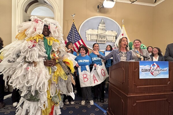 California Democratic state Sen. Catherine Blakespear gestures toward a person covered in plastic bags during a news conference at the Capitol in Sacramento, Calif., on Thursday, Feb. 8, 2024. Blakespear has authored a bill that would ban all plastic shopping bags in California. (AP/Adam Beam)