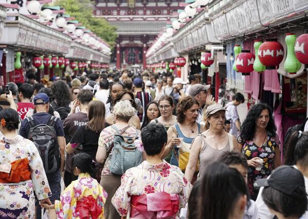 The Nakamise shopping street to Sensoji temple is crowded with visitors and foreign tourists in the Asakusa district in Tokyo Japan, on July 19, 2023. Japan’s economic growth jumped at an annual pace of 6% in the April-June period, marking the third straight quarter of growth as exports and inbound tourism recovered.(Kyodo News via AP)