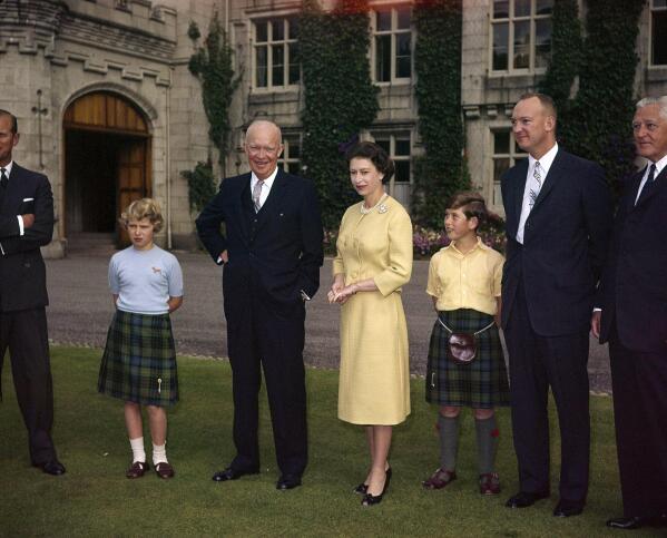 FILE - Britain's Queen Elizabeth II stands on the grounds of Balmoral Castle, in Royal Deeside, Scotland, with U.S. President Dwight D. Eisenhower, Aug. 29, 1959. From left to right are: Prince Philip, partially hidden, Princess Anne, Eisenhower, Queen Elizabeth II and Prince Charles. The two men on the right are unidentified. (AP Photo, File)