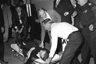 Lee Harvey Oswald, accussed assassin of President John F. Kennedy, is placed on a stretcher after being shot in the stomach in Dallas, Texas, Sunday, Nov. 24, 1963.  Nightclub owner Jack Ruby shot and killed Oswald as the prisoner was being transferred through the underground garage of Dallas police headquarters.  (AP Photo/David F. Smith)