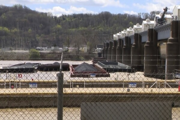 A group of barges sit pinned against the Emsworth lock and dam in Pittsburgh, on Saturday, April 13, 2024. More than two dozen river barges broke loose from their moorings and floated down the Ohio River, damaging a marina and striking a bridge. (WTAE via AP)