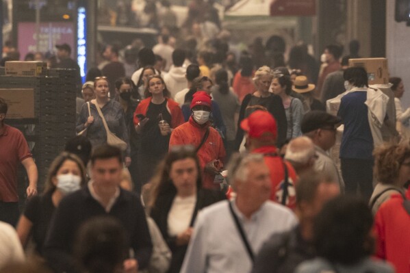 FILE - People wear face masks as they walk outside in the smoke-filled air in Herald Square, June 7, 2023, in New York. As smoky as the summer has been so far, scientists say it will likely be worse in future years because of climate change. (AP Photo/Yuki Iwamura, File)