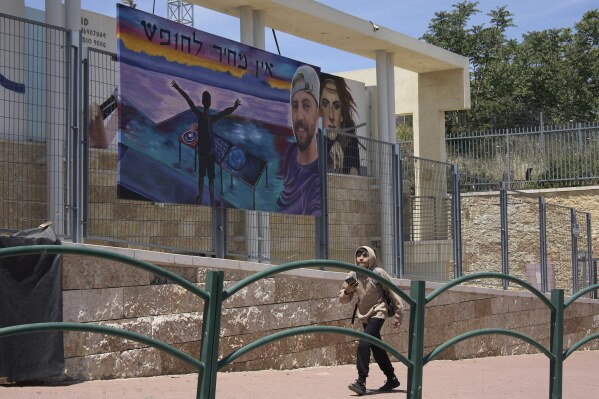 A painting of Elkana Bohbot, who was abducted and brought to Gaza on Oct. 7, 2023, is hung in his family's hometown of Mevaseret Zion, Israel, Wednesday, May 7, 2025. Hebrew reads, 