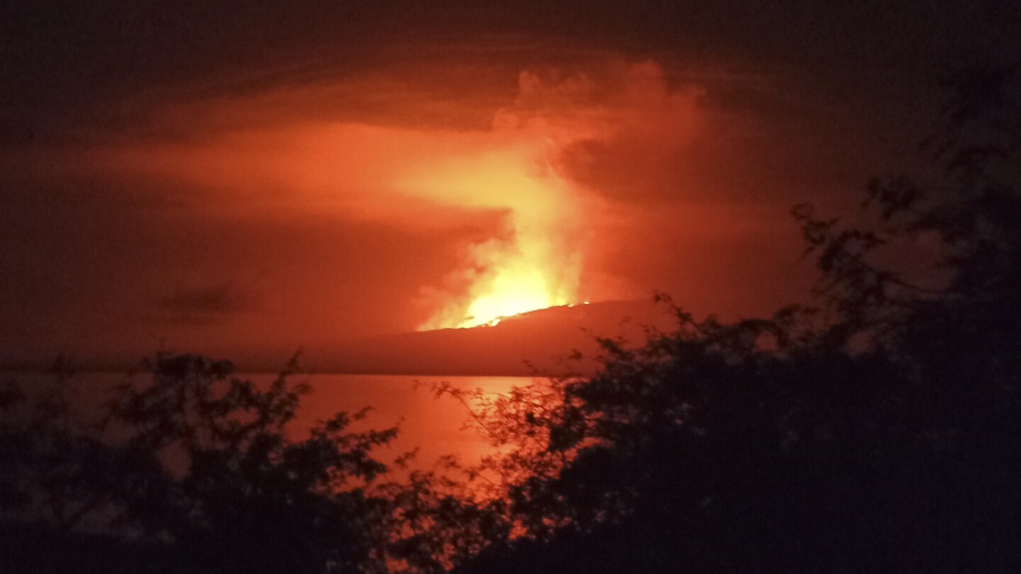 A volcano on an uninhabited Galapagos island erupts and sends lava flowing to the sea