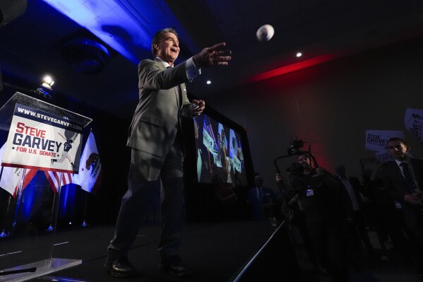 Republican U.S. Senate candidate Steve Garvey tosses a baseball to supporters during his election night party, Tuesday, March 5, 2024, in Palm Desert, Calif. (AP Photo/Gregory Bull)