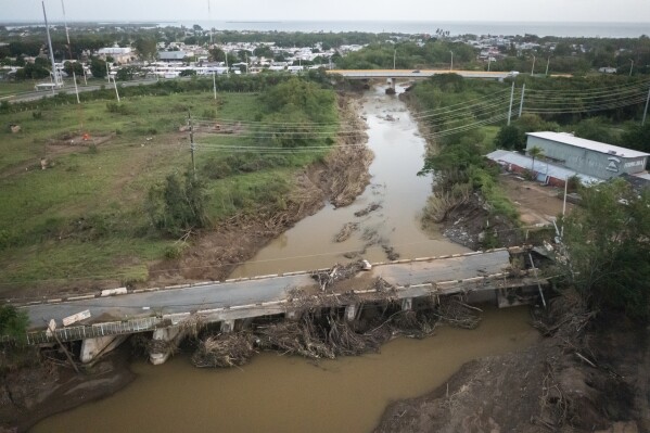 FILE - A bridge is damaged after Hurricane Fiona hit Villa Esperanza in Salinas, Puerto Rico, Sept. 21, 2022. Puerto Rico continues reconstruction work after two devastating hurricanes and a string of strong earthquakes, spending less than 10% of the more than $23 billion available in federal funds, according to a U.S. government report released on Tuesday, Feb. 13, 2024. (AP Photo/Alejandro Granadillo, File)