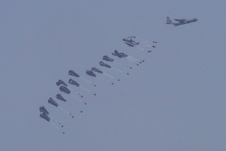 An aircraft airdrops humanitarian aid over the northern Gaza Strip, as seen from southern Israel, Sunday, March 31, 2024. (AP Photo/Tsafrir Abayov)