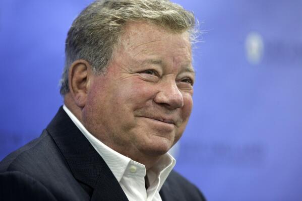 FILE - In this May 6, 2018 file photo, actor William Shatner takes questions from reporters after delivering the commencement address at New England Institute of Technology graduation ceremonies, in Providence, R.I. Star Trek’s Captain Kirk is rocketing into space this month — boldly going where no other sci-fi actors have gone. Jeff Bezos’ space travel company, Blue Origin, announced Monday, Oct. 4, 2021 that Shatner will blast off from West Texas on Oct. 12.  (AP Photo/Steven Senne, file)