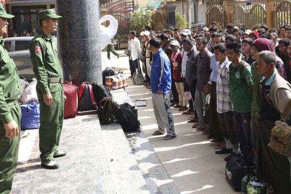 In this photo provided by The Kokang online media, officers of the Myanmar National Democratic Alliance Army ethnic armed organizations speak to the soldiers of the army battalion and their family members who surrendered to them two days earlier, in Kokang Self-Administered Zone in Myanmar's northern Shan state, Tuesday Nov. 14, 2023. (The Kokang online media via AP)