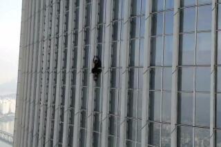 This photo provided by the Seoul Metropolitan Fire and Disaster Management Headquarters, shows an unidentified British man climbing Lotte World Tower, the tallest skyscraper in the country, in Seoul, South Korea, Monday, June 12, 2023. The British man was detained after climbing more than half way up the world’s fifth-tallest skyscraper in Seoul with only his bare hands on Monday, authorities said. (The Seoul Metropolitan Fire and Disaster Management Headquarters, via AP).