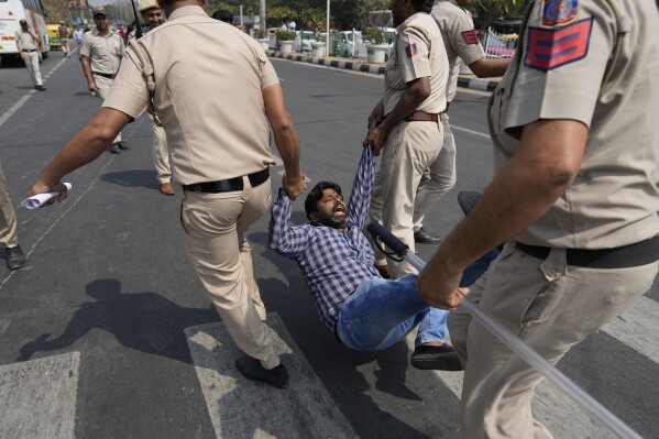 A supporter of Aam Admi Party, or Common Man's Party, is detained by the police officials during a protest against the arrest of their party leader Arvind Kejriwal, in New Delhi, India, Friday, March 22, 2024. Supporters of an anti-corruption crusader and one of India's most consequential politicians of the last decade in India held protests Friday against his arrest, which opposition parties say is part of a crackdown by Prime Minister Narendra Modi's government before national elections. (AP Photo/Manish Swarup)