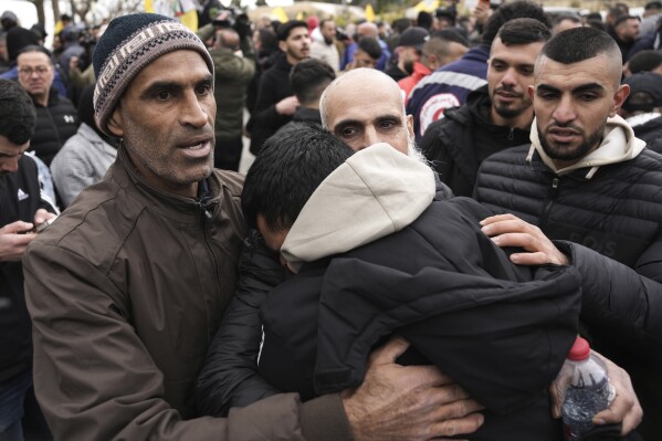 Palestinian prisoners are greeted as they exit a Red Cross bus after being released from Israeli prison following a ceasefire agreement between Israel and Hamas, in the West Bank city of Ramallah, Saturday Feb. 8, 2025. (AP Photo/Mahmoud Illean)