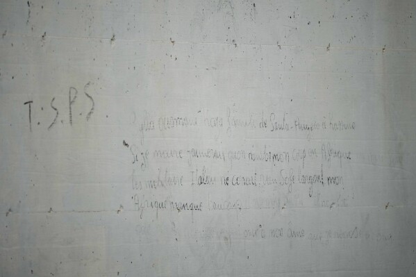 Writings left by Ousmane Sylla, a 21-year-old Guinean, are seen on a wall of the Ponte Galeria center in Rome, Tuesday, March 19, 2024, at the site of his apparent suicide. He was held in one of the facilities created in Italy to detain migrants ahead of their repatriation, as they are considered ineligible for refugee status or international protection, (AP Photo/Andrew Medichini)
