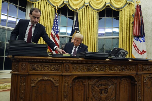 President Donald Trump signs executive orders in the Oval Office of the White House, Monday, Jan. 20, 2025, in Washington. (AP Photo/Evan Vucci)