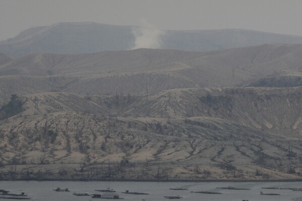 FILE - A small steam rises from Taal Volcano, Batangas province, Philippines on Friday July 2, 2021. Smog containing gases from a restive Philippine volcano sickened dozens of students and prompted 25 towns and cities to shut their schools on Friday, Sept. 22, 2023, as a health precaution, officials said. (AP Photo/Aaron Favila, File)