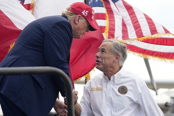 Republican presidential candidate and former President Donald Trump, left, shakes hands with Texas Gov. Greg Abbott, right, after he received Abbott's endorsement at the South Texas International Airport Sunday, Nov. 19, 2023, in Edinburg, Texas. (AP Photo/Eric Gay)