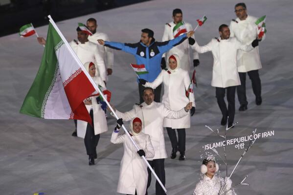 FILE - Samaneh Beyrami Baher carries the flag of Iran during the opening ceremony of the 2018 Winter Olympics in Pyeongchang, South Korea, in this Friday, Feb. 9, 2018, file photo. A group of athletes and human rights activists is calling on the IOC to sanction Iran's Olympic program for what it says is the country's long-running pattern of ordering athletes to avoid competing against Israelis in international events.  (AP Photo/Michael Sohn, File)