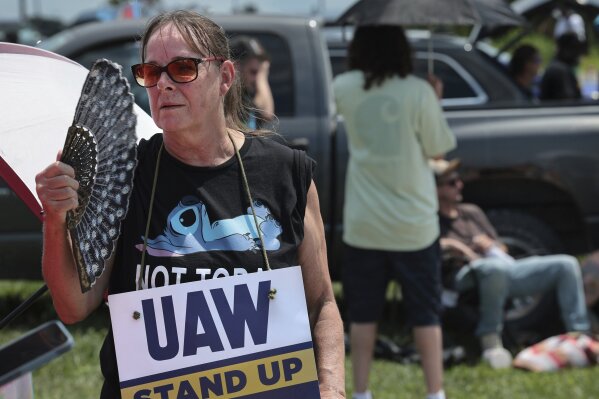 Assembly line worker Sheila Buckley tries to keep cool while on the picket line as members of United Auto Workers Local 282 are on strike against Lear, a car and truck seat manufacturer in Wentzville, Mo. on Tuesday, July 23, 2024. The strike led to a shutdown at the nearby GM assembly plant. (Robert Cohen/St. Louis Post-Dispatch via AP)