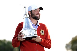 Scottie Scheffler holds the championship trophy after winning the Arnold Palmer Invitational golf tournament Sunday, March 10, 2024, in Orlando, Fla. (AP Photo/John Raoux)