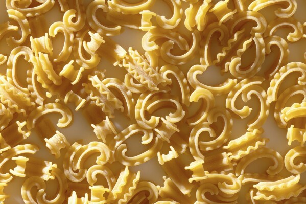 This image shows a new pasta shape called cascatelli, created by food writer and podcaster Dan Pashman. Pashman's “Anything's Pastable” features dishes using 34 different pasta shapes, but especially features his cascatelli, a graceful, ruffled-edged curved shape that resembles a quotation mark. Time magazine declared cascatelli one of 2021’s best inventions. (Scott Bleicher via AP)