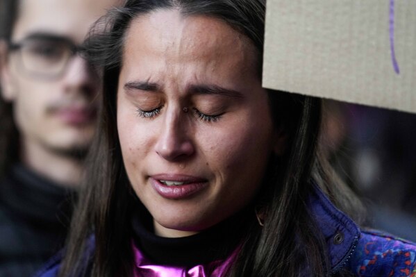 FILE - A student cries during a flash mob 'A minute of noise for Giulia' for Giulia Cecchettin, allegedly killed at the hands of her possessive ex-boyfriend, outside the Statale University, in Milan, Italy, Wednesday, Nov. 22, 2023. Outrage over violence against women is mounting in Italy, with students leading the way. Young people across the country have taken to pounding on classroom desks in unison to demand an end to the slayings of women by men and to root out corrosive, patriarchal attitudes that have long been a part of Italian society. Opposition lawmakers did the same in parliament. (AP Photo/Luca Bruno, file)
