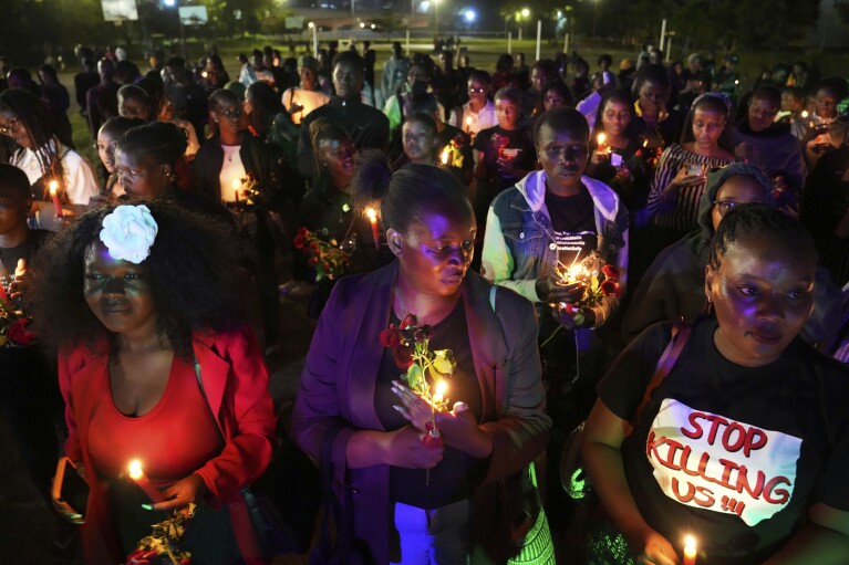 Women hold candles and flowers during a "Dark Valentine" vigil to demonstrate against the rising cases of femicide, in downtown Nairobi, Kenya, Wednesday, Feb. 14, 2024. (AP Photo/Brian Inganga)