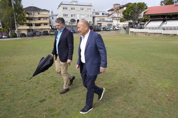 Australian Rugby's head coach Eddie Jones, right, and Mark McCartney, head of communications for Rugby Australia, stroll on the pitch at Coogee Oval before Jones speaks to media in Sydney, Tuesday, Oct. 17, 2023. Wallabies head coach, Jones, says he is 