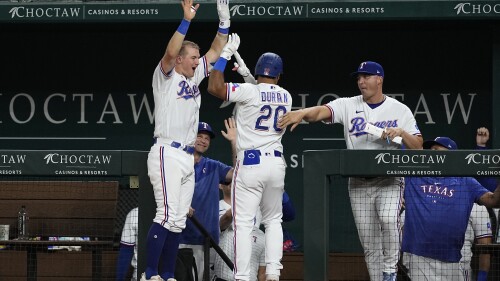 Texas Rangers' Josh Jung, left, Ezequiel Duran (20) and first base coach Corey Ragsdale, right, celebrate after Duran's two-run home run in the sixth inning of a baseball game against the Tampa Bay Rays, Monday, July 17, 2023, in Arlington, Texas. Robbie Grossman also scored on the shot. (AP Photo/Tony Gutierrez)