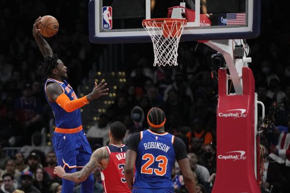 New York Knicks forward Julius Randle, left, goes up for a dunk over Washington Wizards forward Kyle Kuzma and Knicks center Mitchell Robinson in the first half of an NBA basketball game, Friday, Feb. 24, 2023, in Washington. (AP Photo/Patrick Semansky)