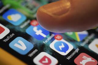 A user scrolls through various social media apps on their phone. (AP Photo/Jenny Kane)